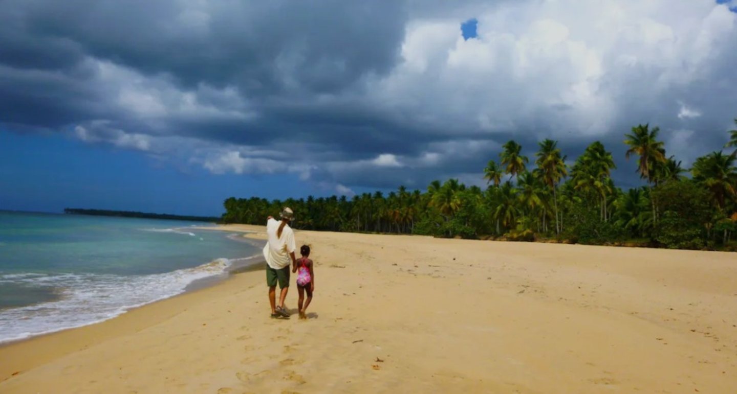 Personas paseando por la playa de Cosón